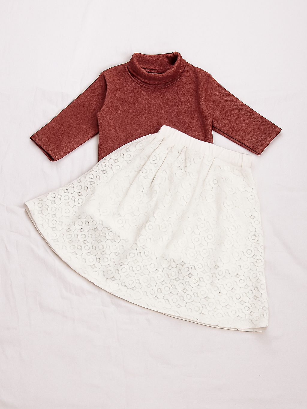 Children's outfit with rust-colored turtleneck and white lace skirt